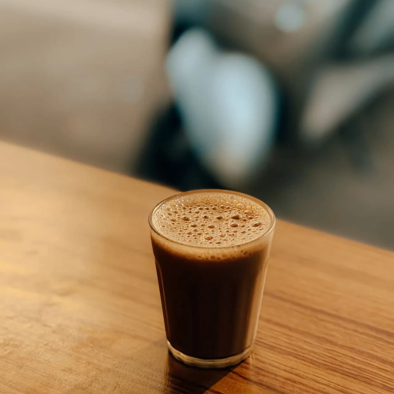 A glass of chai on a wooden table